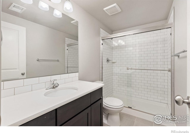 bathroom with toilet, an enclosed shower, vanity, and tile patterned floors