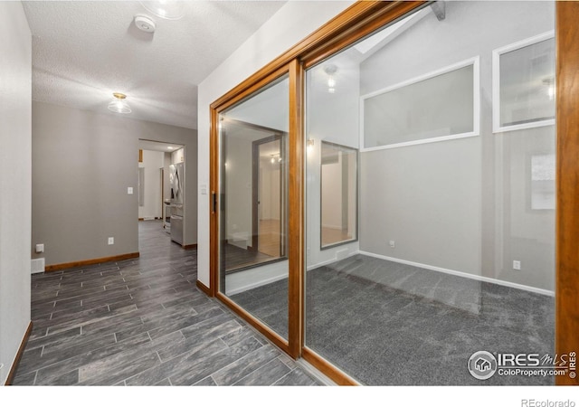 interior space with lofted ceiling, dark wood-type flooring, and a textured ceiling