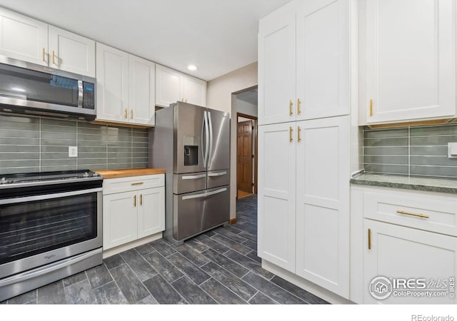 kitchen with wood counters, dark hardwood / wood-style flooring, backsplash, stainless steel appliances, and white cabinets