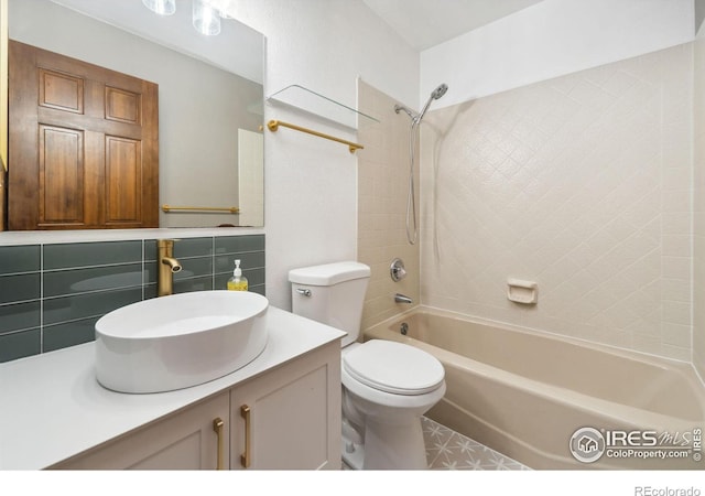 full bathroom with toilet, vanity, tile walls, and tiled shower / bath