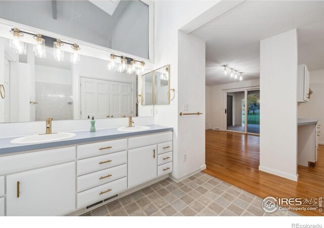 bathroom with wood-type flooring, vanity, and walk in shower