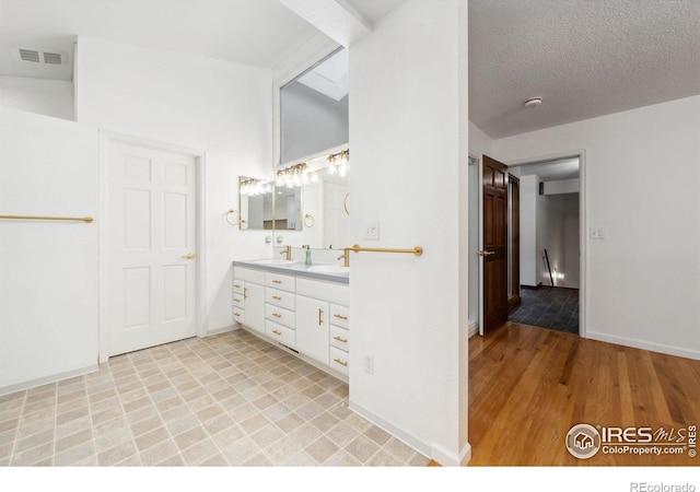 bathroom featuring hardwood / wood-style floors, vanity, and a textured ceiling