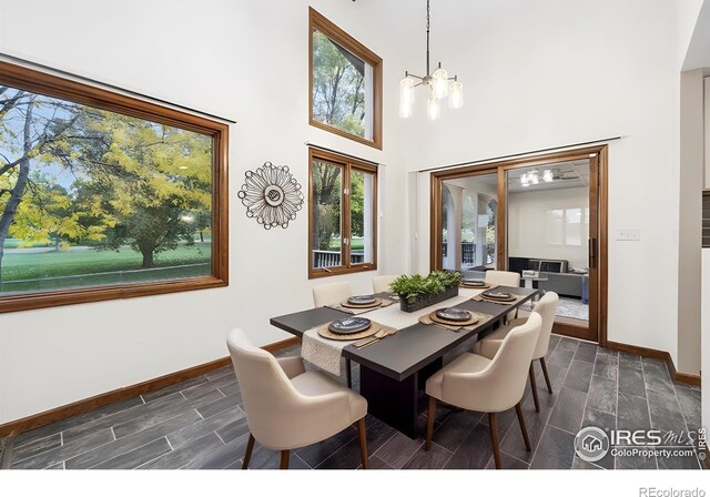 dining space featuring french doors, dark hardwood / wood-style flooring, a high ceiling, and a notable chandelier