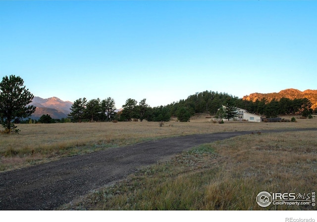 view of road with a rural view and a mountain view