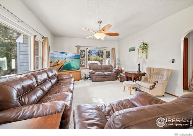 living room with light carpet, a textured ceiling, and ceiling fan