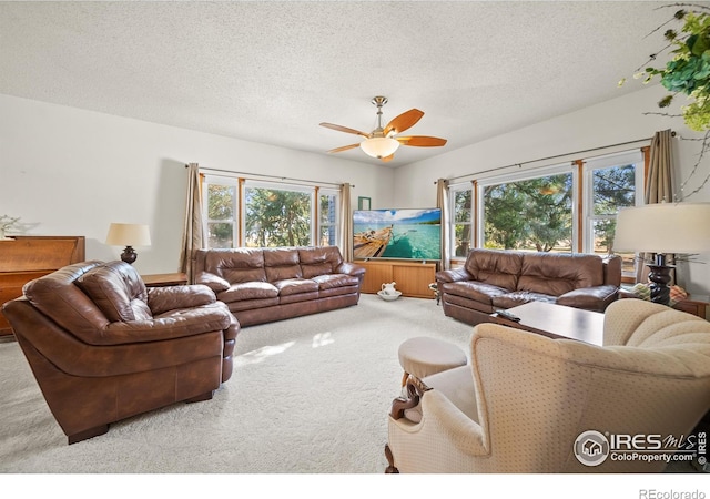 living room with carpet flooring, a textured ceiling, and ceiling fan