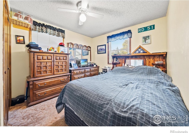 carpeted bedroom with a textured ceiling and ceiling fan