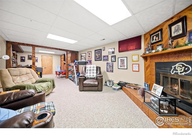 living room featuring carpet and a drop ceiling