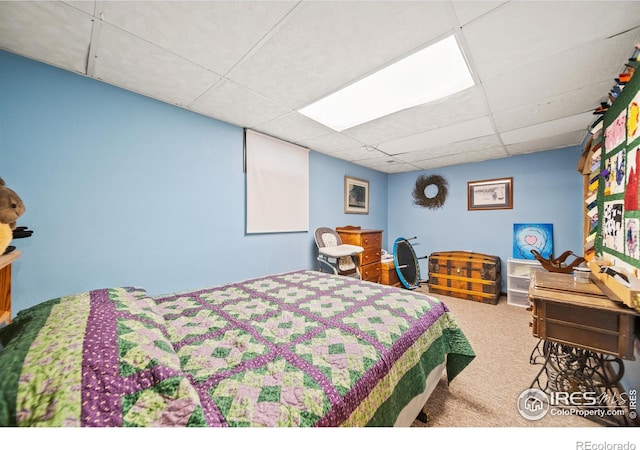 bedroom featuring carpet and a drop ceiling