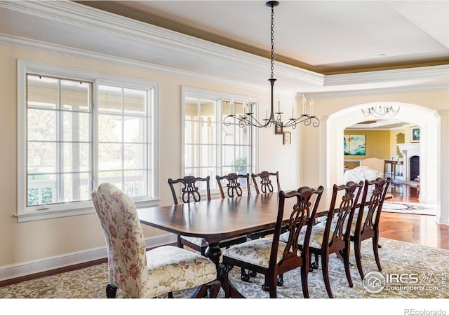 dining room with ornamental molding, a tray ceiling, and hardwood / wood-style floors