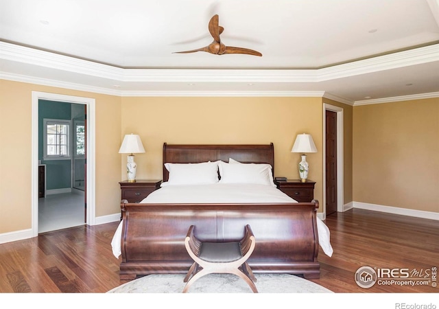 bedroom featuring dark wood-type flooring, ceiling fan, crown molding, and a raised ceiling