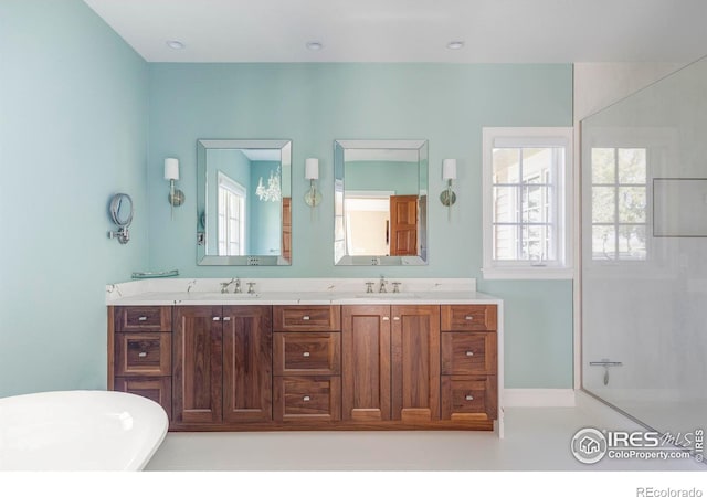 bathroom with vanity, a tub to relax in, and a wealth of natural light