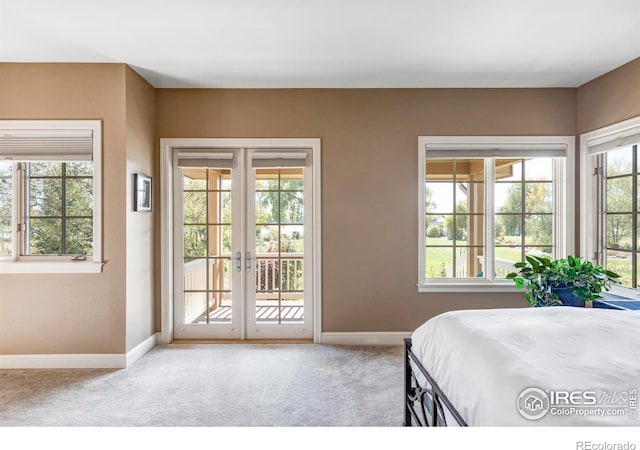 bedroom with french doors, access to outside, and light colored carpet