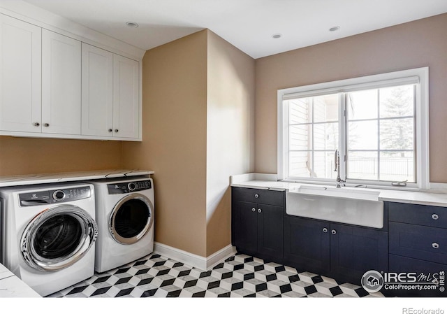 washroom with sink, cabinets, and washer and clothes dryer