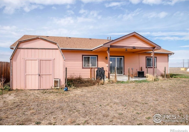 rear view of house featuring a storage unit