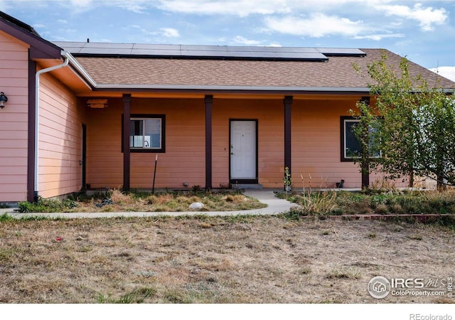 view of front of home featuring solar panels and covered porch