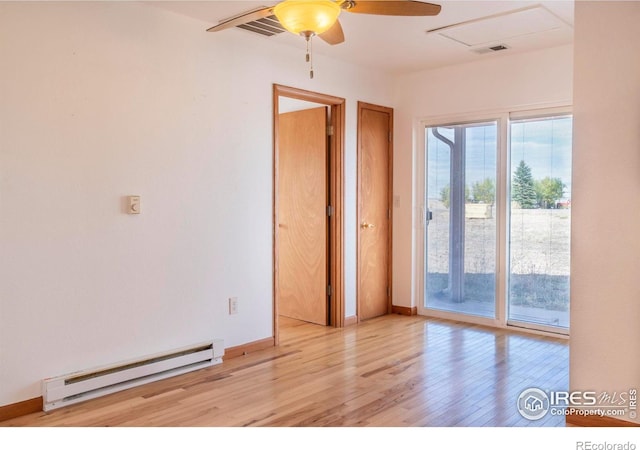 spare room with baseboard heating, light hardwood / wood-style floors, and ceiling fan