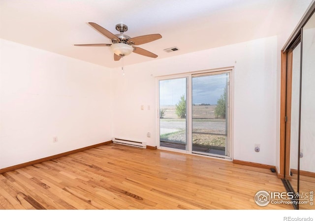 spare room with ceiling fan, a baseboard radiator, and light wood-type flooring