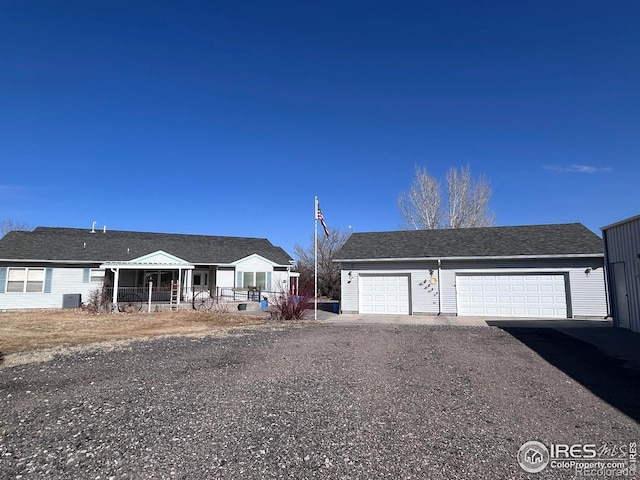 view of front of home featuring an outbuilding, central air condition unit, and gravel driveway