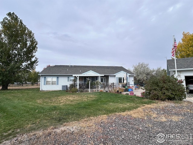 view of front of property with covered porch, cooling unit, and a front lawn