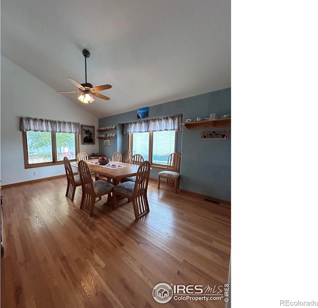 dining room with visible vents, ceiling fan, baseboards, lofted ceiling, and wood finished floors