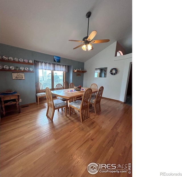 dining space featuring baseboards, high vaulted ceiling, light wood-type flooring, and a ceiling fan