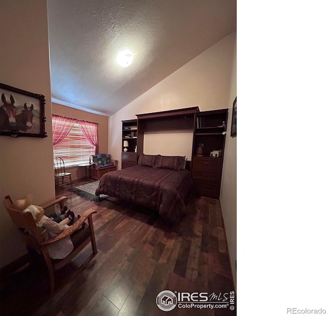 bedroom featuring vaulted ceiling, a textured ceiling, and wood finished floors