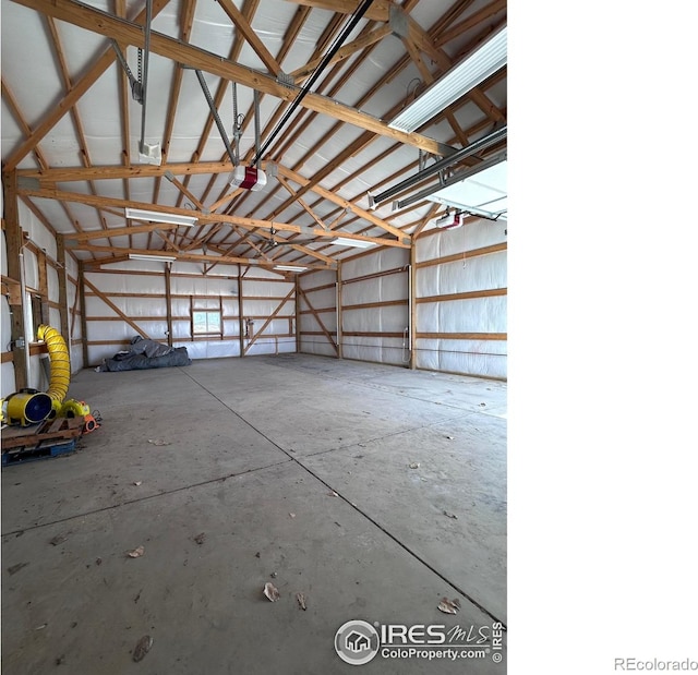 garage featuring a garage door opener and metal wall