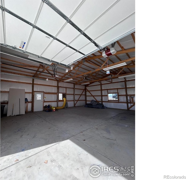 garage featuring a garage door opener and metal wall