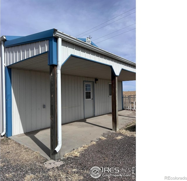 back of property with a carport and a patio