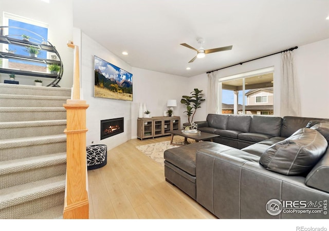 living room with light hardwood / wood-style flooring and ceiling fan