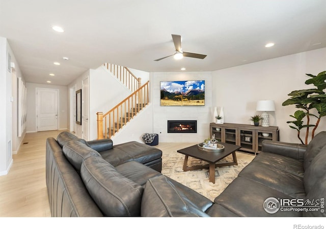 living room featuring light hardwood / wood-style floors and ceiling fan