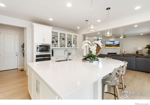 kitchen featuring a large island, white cabinetry, and light wood-type flooring