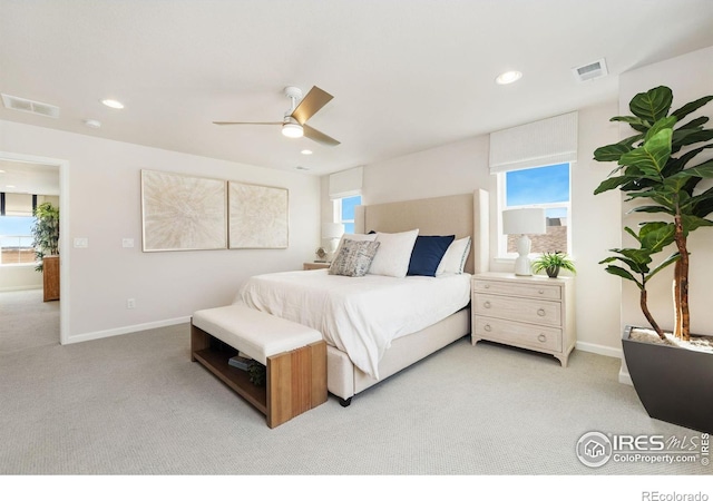 carpeted bedroom with multiple windows and ceiling fan