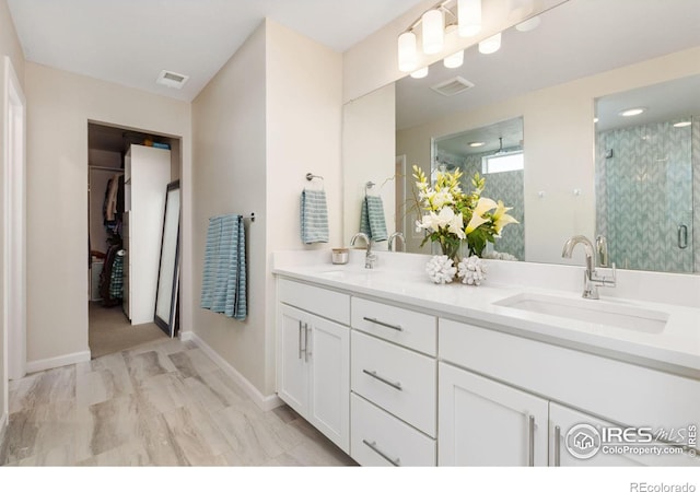 bathroom with a shower with door and vanity