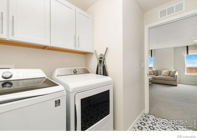 laundry area with cabinets, light carpet, and washing machine and clothes dryer