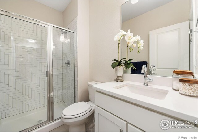 bathroom featuring vanity, toilet, and walk in shower