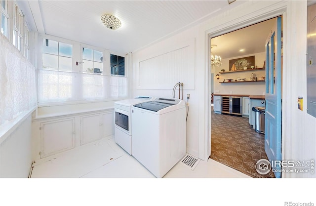 laundry area with washing machine and dryer, an inviting chandelier, and plenty of natural light