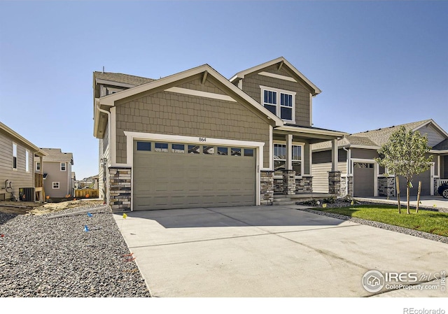 craftsman inspired home with central AC unit and a garage