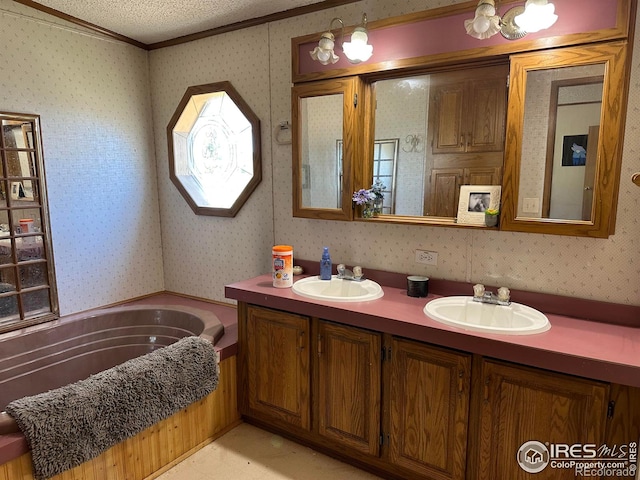 bathroom featuring vanity, a textured ceiling, a bathtub, and ornamental molding