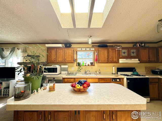 kitchen featuring a textured ceiling, white appliances, a kitchen island, and sink