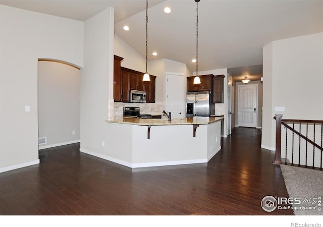 kitchen featuring backsplash, stainless steel appliances, decorative light fixtures, and dark hardwood / wood-style flooring