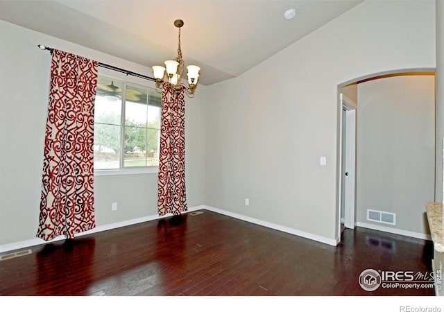 unfurnished room with a notable chandelier and dark hardwood / wood-style flooring