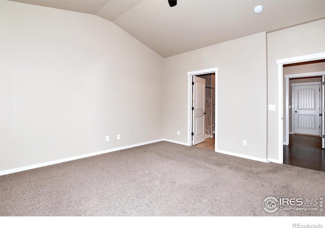 carpeted spare room featuring vaulted ceiling