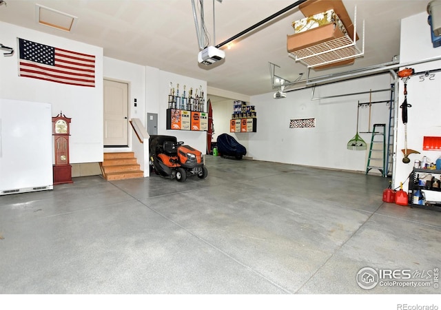 garage featuring a garage door opener, electric panel, and white refrigerator