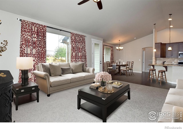 living room featuring lofted ceiling and ceiling fan with notable chandelier