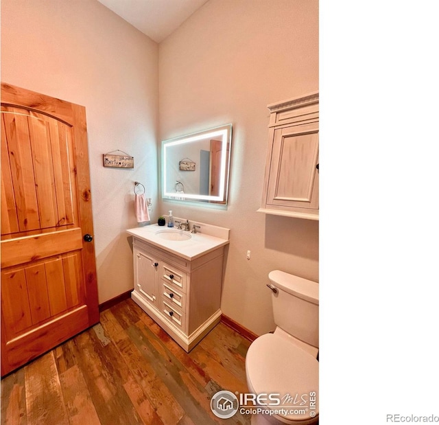 bathroom with vanity, toilet, and hardwood / wood-style floors