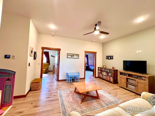 living room with light hardwood / wood-style floors and ceiling fan