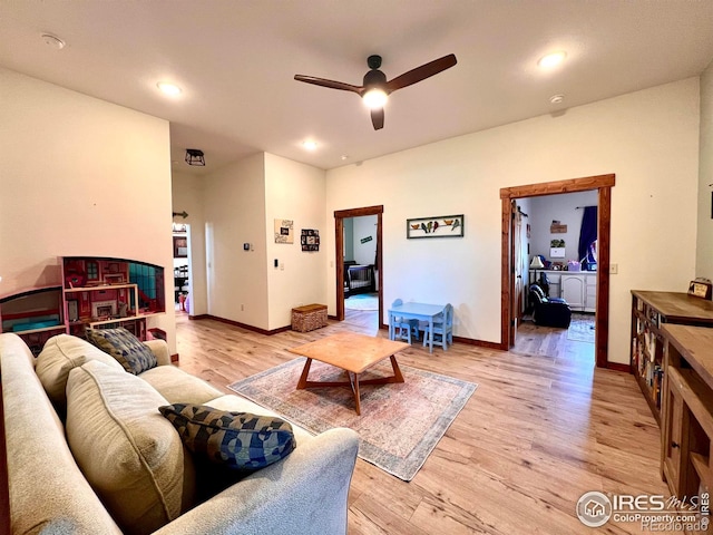 living room featuring ceiling fan and light hardwood / wood-style flooring