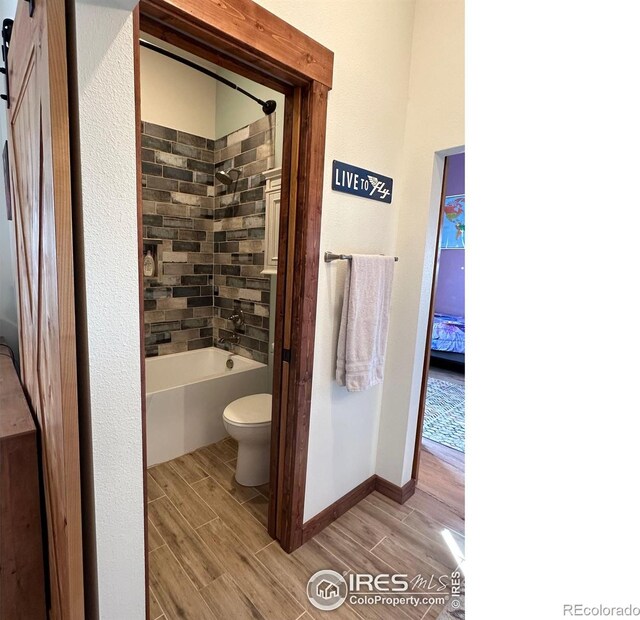 bathroom with tiled shower / bath and toilet